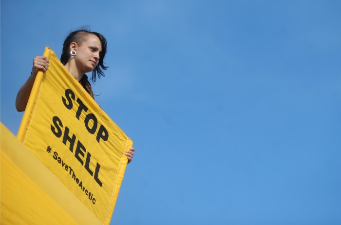 A Greenpeace activist holds a banner dur